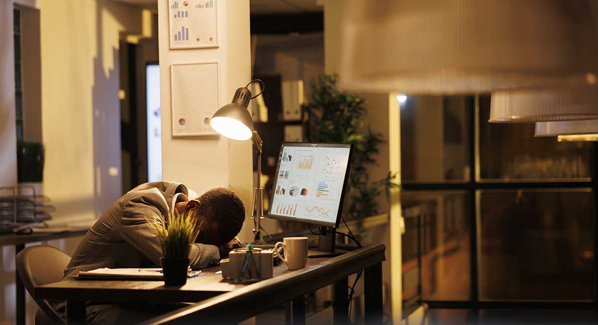 tired drained employee sleeping at desk from burnout